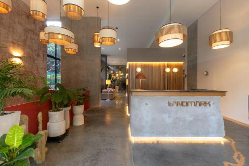 a lobby with potted plants and pendant lights at Landmark Hotel in Medellín