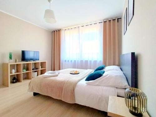una camera con un grande letto e una finestra di Meraki Apartments a Danzica