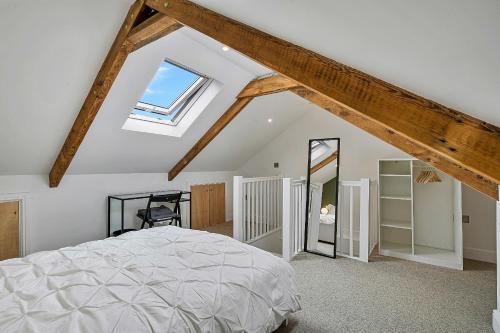 a attic bedroom with a bed and a skylight at Finest Retreats - Poppy Cottage of Penzance in Penzance