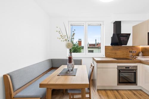 a kitchen with a table and a vase with flowers on it at Wienerberg-Apartments in Vienna