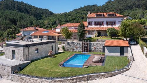 a house with a swimming pool in a yard at Casas de Tourim in Arcos de Valdevez