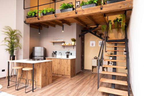 a loft office with a staircase and a kitchen with plants at Royal Living Poblado in Medellín