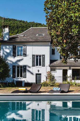 une maison et une piscine devant une maison dans l'établissement Luxury Pyrenees Villa, Tourmalet, gardens, gym, à Adast