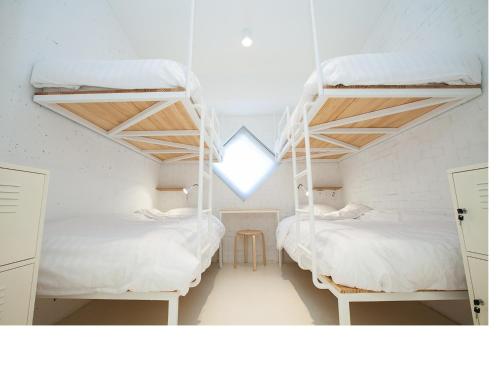 two bunk beds in a room with a window at Mir Guesthouse in Jeju