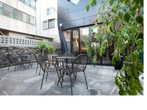 a row of tables and chairs in front of a building at Mir Guesthouse in Jeju