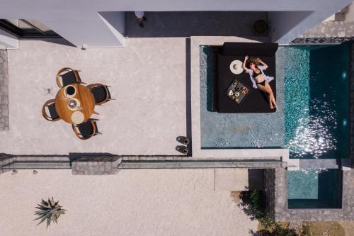 an overhead view of a woman standing next to a swimming pool at Milestones Naxos in Naxos Chora