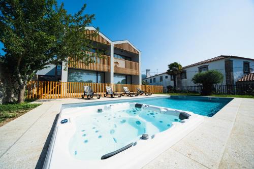 a swimming pool in front of a house at Casa João Eusébio 2 in Ponte de Lima