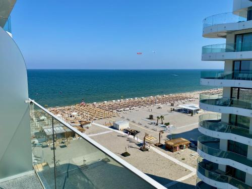 Blick auf einen Strand mit Sonnenschirmen und ein Gebäude in der Unterkunft Studio 147 Mamaia Nord in Mamaia