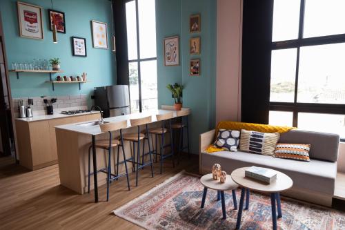 a living room with a couch and a kitchen at Royal Living Poblado in Medellín