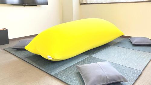 a yellow bean bag chair sitting on a carpet at Global Resort ONO de LUNE in Hatsukaichi