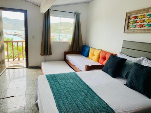 a living room with two beds and a couch at Flat vista incrível in Arraial do Cabo