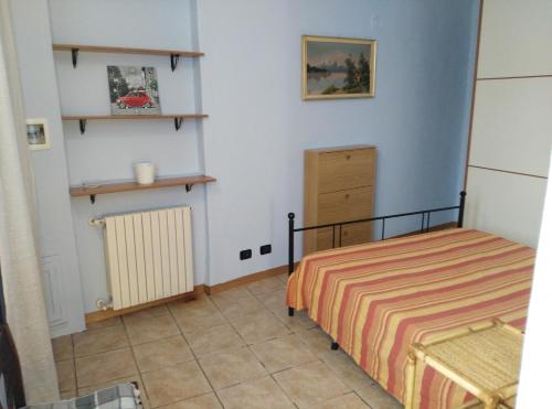 a small bedroom with a bed and a radiator at Casa Mauri in Asti