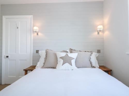 a white bedroom with a white bed with a star on it at Marroy in Salcombe