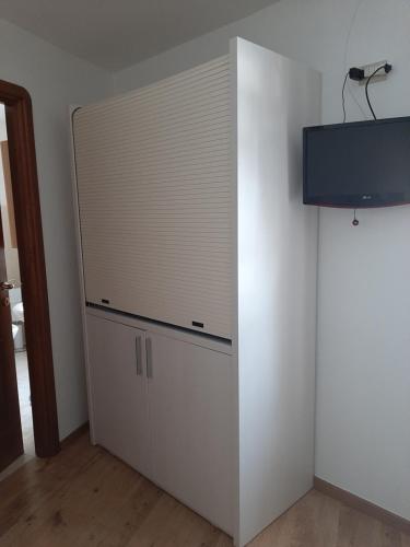 a white closet with a tv on a wall at Alloggi Il Rododendro in Bagni di Vinadio