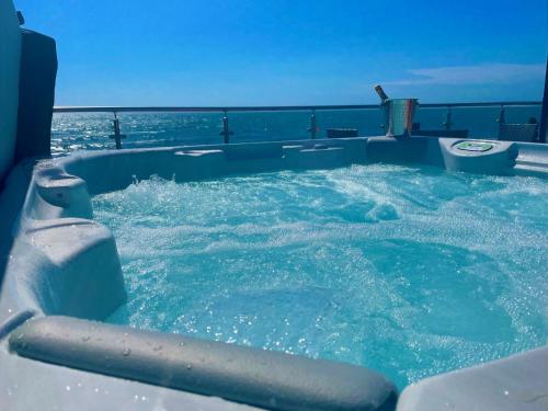 a jacuzzi tub with the ocean in the background at 4 Sinclair bay lodges in Keiss