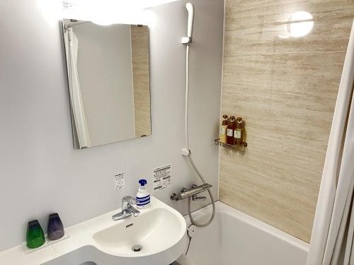a bathroom with a sink and a mirror and a shower at Global Resort ONO de LUNE in Hatsukaichi