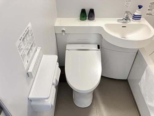 a bathroom with a white toilet and a sink at Global Resort ONO de LUNE in Hatsukaichi