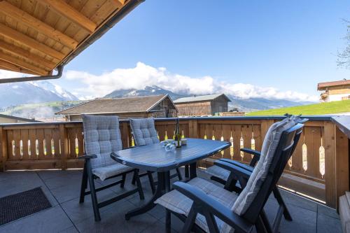 a table and chairs on a deck with a view at Haus am Bach in Kaprun