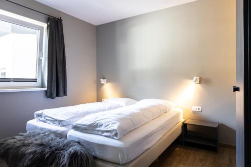 two beds in a room with a window at Haus am Bach in Kaprun