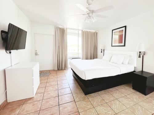 a bedroom with a bed and a flat screen tv at Tropi Rock in Fort Lauderdale