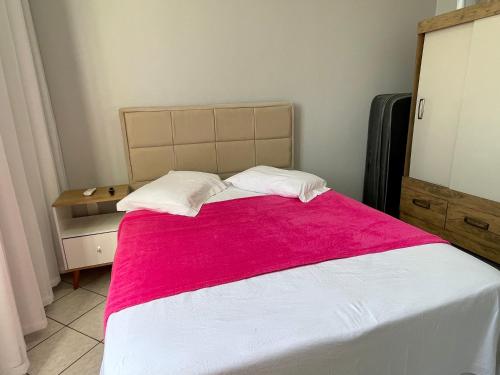 1 dormitorio con 1 cama grande con manta roja en Ingleses Topázio 100m mar 1Q, en Florianópolis