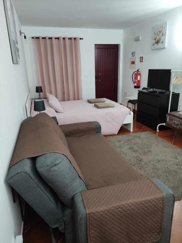 a bedroom with two beds and a couch at Di&Ana I - Alojamento Vila Viçosa in Vila Viçosa