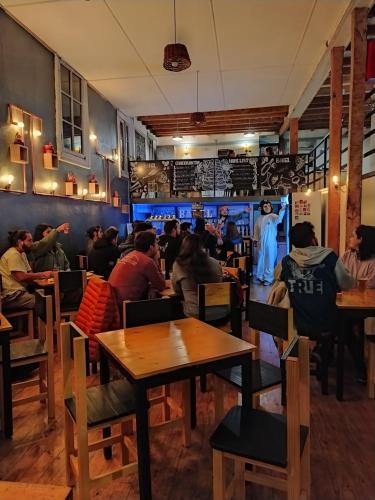 a group of people sitting at tables in a restaurant at Casa Volante Hostal in Valparaíso