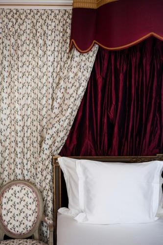 a bedroom with a bed and a red curtain at Relais & Château Louise de La Vallière in Reugny