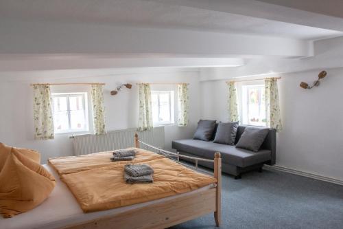 1 dormitorio con 1 cama y 1 sofá en Umgebindehaus an der Mandau, en Großschönau