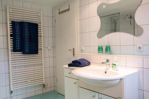 a white bathroom with a sink and a mirror at Umgebindehaus an der Mandau in Großschönau