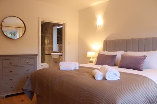 a bedroom with a large bed with towels on it at The Anchorage Nables Farm in Chippenham