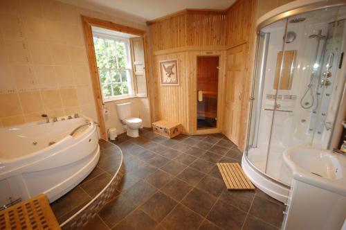 een badkamer met een bad, een douche en een wastafel bij The Old Manse, Fochabers in Fochabers