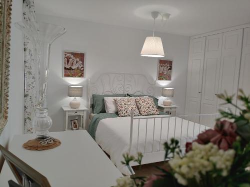 Un dormitorio con una cama y una mesa con flores. en LUXURY DUPLEX ATLANTIC FOUR SEASONS, en Santa Cruz de Tenerife