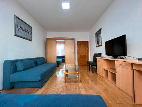 a living room with a blue couch and a television at Stan na dan Sebastijan in Banja Luka