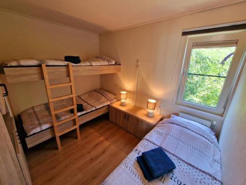 sypialnia z 2 łóżkami piętrowymi i drabiną w obiekcie De droom van Zeeland met jacuzzi & Finse sauna w mieście Sint Annaland