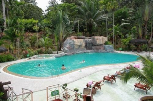 a large swimming pool with people in the water at Sepilok Jungle Resort in Sepilok