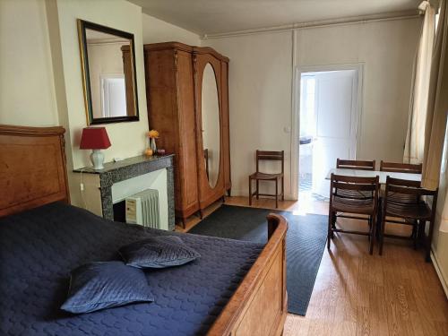 um quarto com uma cama azul, uma mesa e cadeiras em VILLA ESPERANZA Suite de 2 à 4 personnes proche Zoo de Beauval et châteaux de La Loire em Valençay