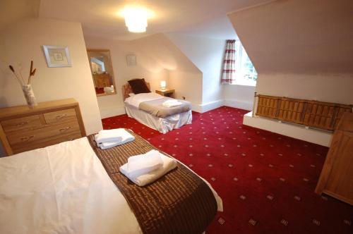 a hotel room with two beds and red carpet at The Old Manse, Fochabers in Fochabers