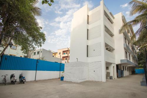 a white building with two motorcycles parked next to it at Magnus Aerith Studios Exclusive Residences in Pune