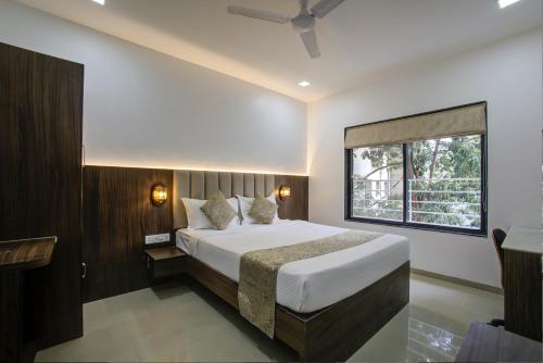 Un dormitorio con una cama grande y una ventana en StayBird - AERITH STUDIOS, Exclusive Residences, Kharadi, en Pune