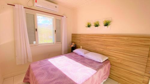 a bedroom with a bed and a window at De Bem K Vida in Ubatuba