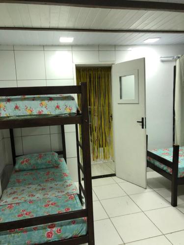 a room with two bunk beds and a door at Pousada Suítes Do Pelô in Salvador