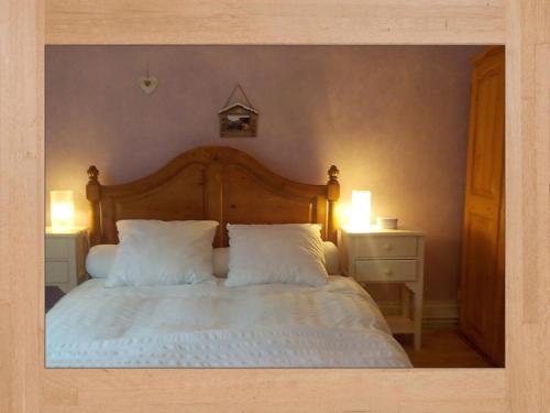 ein Schlafzimmer mit einem großen Bett mit zwei weißen Kissen in der Unterkunft LES LILAS in Sainte-Marie-aux-Mines