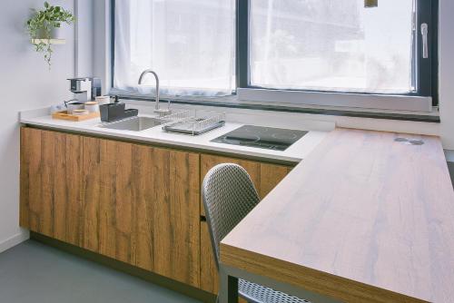 cocina con fregadero y mesa de madera en MONO Apartments en Bolonia