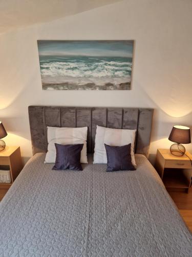 une chambre avec un grand lit avec des oreillers bleus dans l'établissement Apartments Rora, à Rogoznica