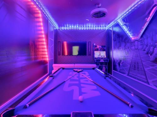 a pool table in a room with purple lights at Marvelous Magical House: Amazing Themes and Pool, 5mi Disney in Kissimmee
