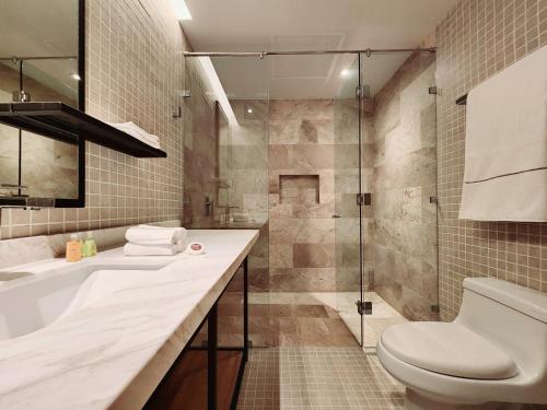 a bathroom with a toilet and a sink and a shower at Singular Dream Beach Residences in Playa del Carmen