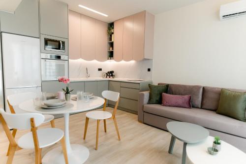 una cucina e un soggiorno con tavolo e divano di Magico Suites City Heart Luxury Appartments a Alexandroupoli