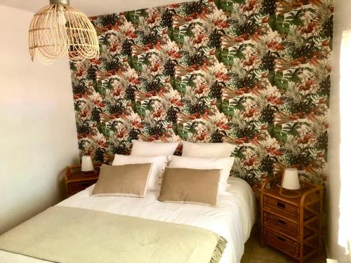 a bedroom with a bed with a floral wallpaper at Domaine Plan des Devens in Roussillon
