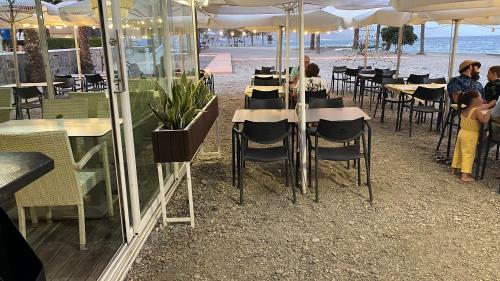 un grupo de personas sentadas en mesas en un restaurante en Victoria loft, en Castell de Ferro